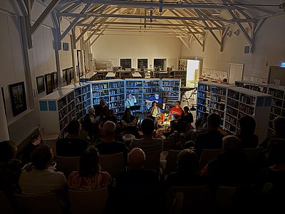 Publikum lauscht einer Lesung in der Bibliothek