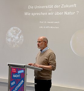 Harald Lesch hält einen Vortrag am Stehpult