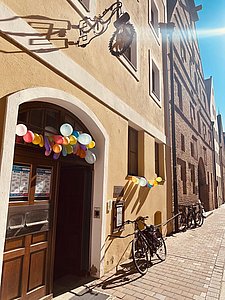 Sonnige Außenansicht der Stadtbücherei Landshut mit Ballongirlande an der Tür