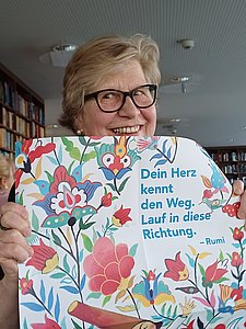  Jule Pfeiffer-Spiekermann hält ein Plakat hoch über das sie hinweg lächelt